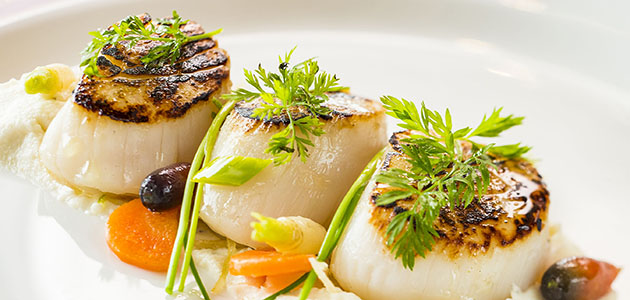Seared sea scallops served at the adult-exclusive restaurant Palo.