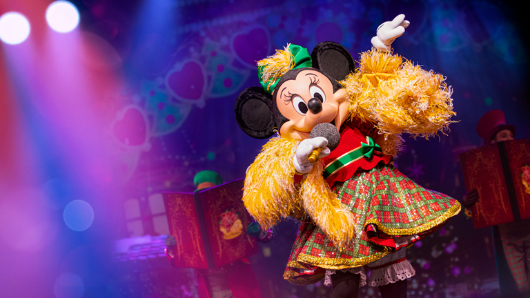 Minnie Mouse singing with a microphone at Let's Sing Christmas! Musical Show