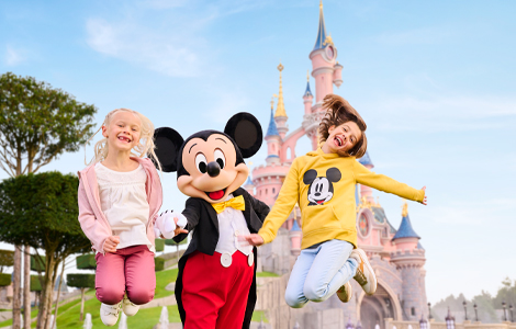 2  children jumping with Mickey Mouse in Disneyland Park