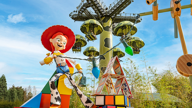 Toy Story's Jessue in front of an attractrion in Worlds of Pixar at Disney Adventure World