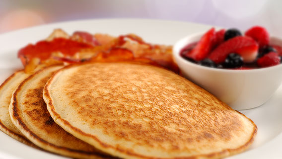 Hot buffet breakfast with pancakes, fruit and bacon