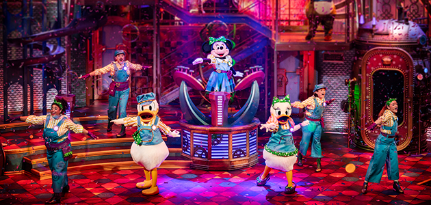 Minnie Mouse in a colourful dress performing on stage at Minnie’s Dream Factory in Disneyland Paris.