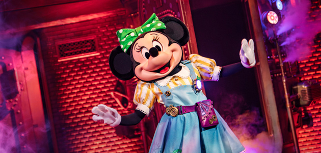 Minnie Mouse in a colourful dress performing on stage at Minnie’s Dream Factory in Disneyland Paris.