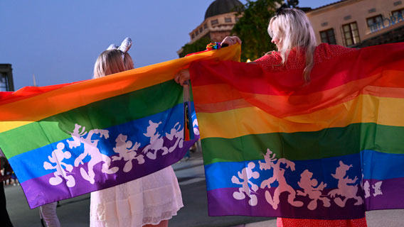 Two females Guests waving their rainbow Pride flags