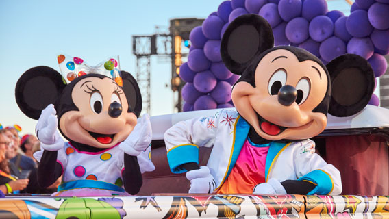 Mickey Mouse and Minnie Mouse on a colourful Pride parade float