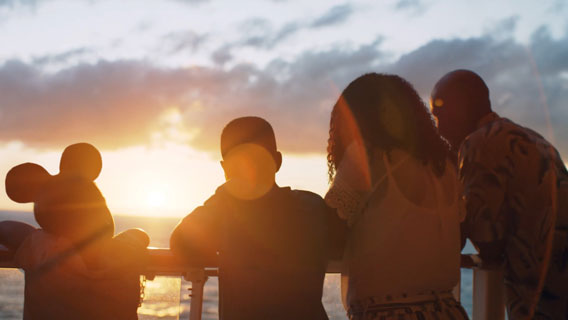 Family on deck watching sunset