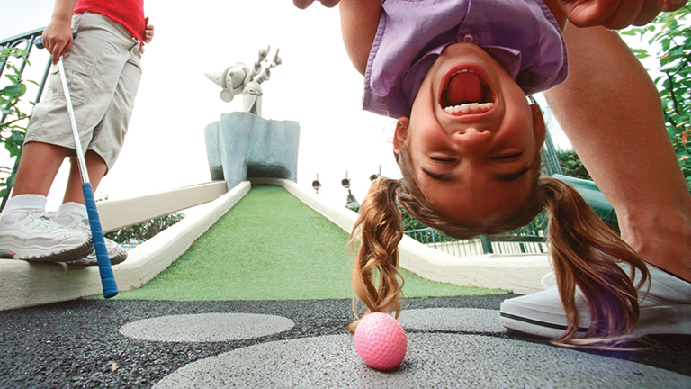 Young guest enjoying a round of mini-golf at Fantasia Gardens