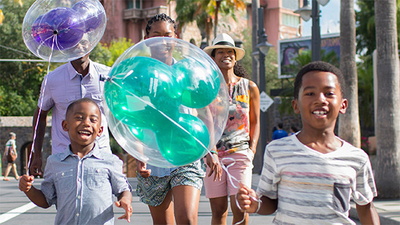 Young guests with Mickey balloons on Sunset Boulevard at Disney's Hollywood Studios